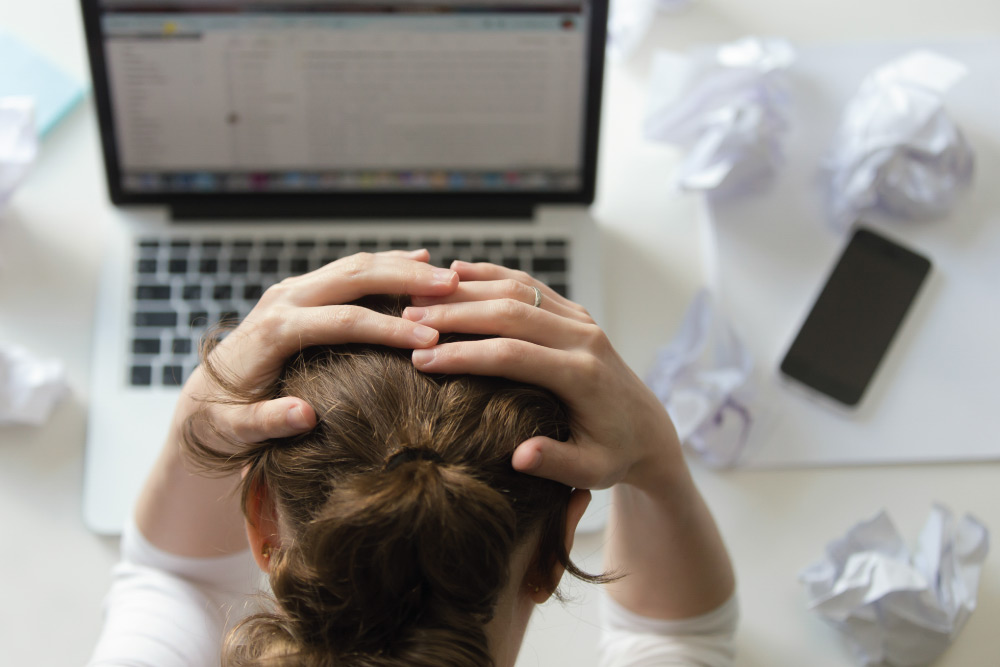 Produttività del team: collaboratore alle prese con email, documenti e software che rallentano il lavoro quotidiano