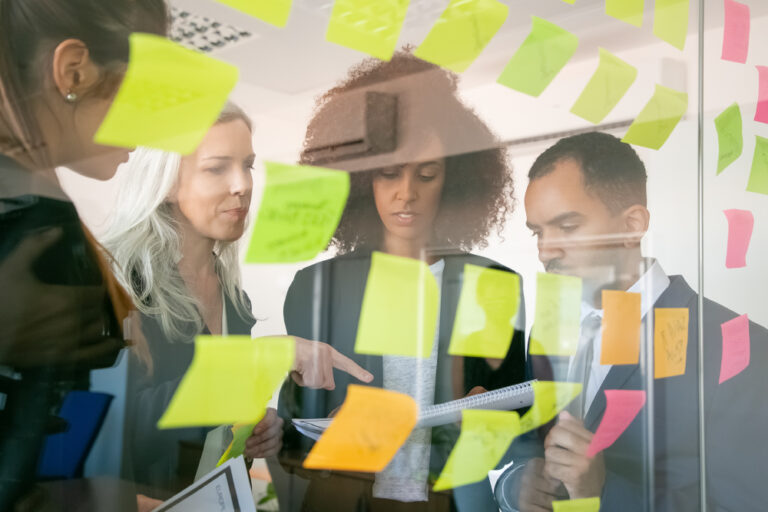 Workshop aziendali: collaboratori analizzano processi reali con post-it e laptop durante una formazione su misura